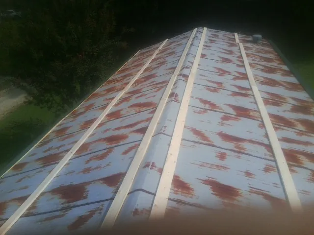 Rusted metal roof panels with new wood purlins before replacement — Storm Damage Roof Repair in Grandin by Roofing Brothers