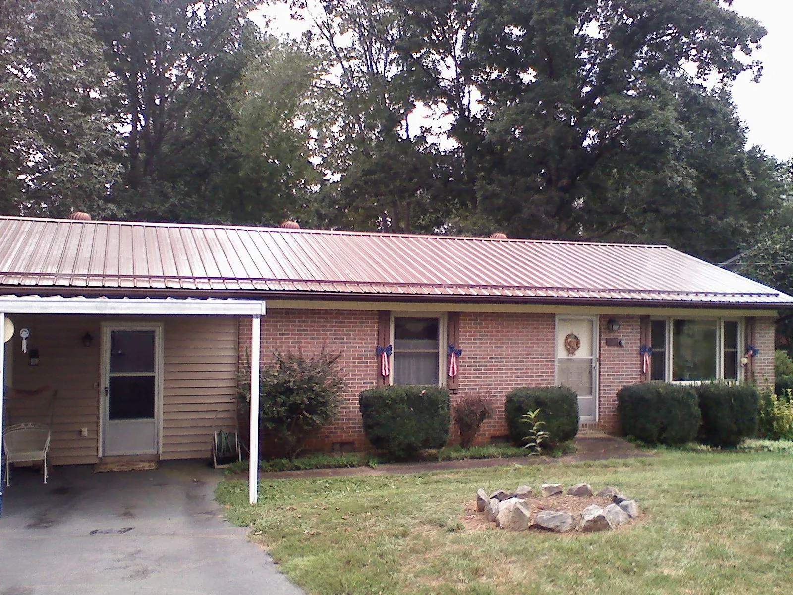 Bronze metal roof and carport on a brick ranch home — Roof Repair work by our crew in Grandin